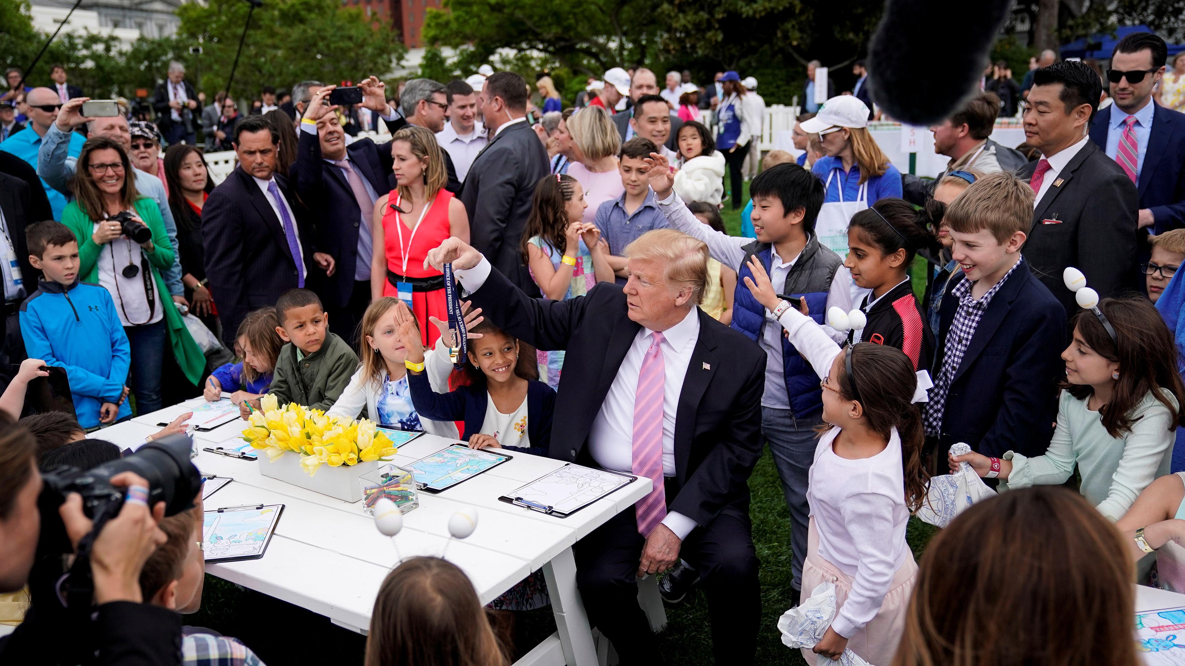 Trump bietet einem Kind seine Pfeife an während Bilder für Militärmitglieder gemalt werden in Washington am 22.04.2019