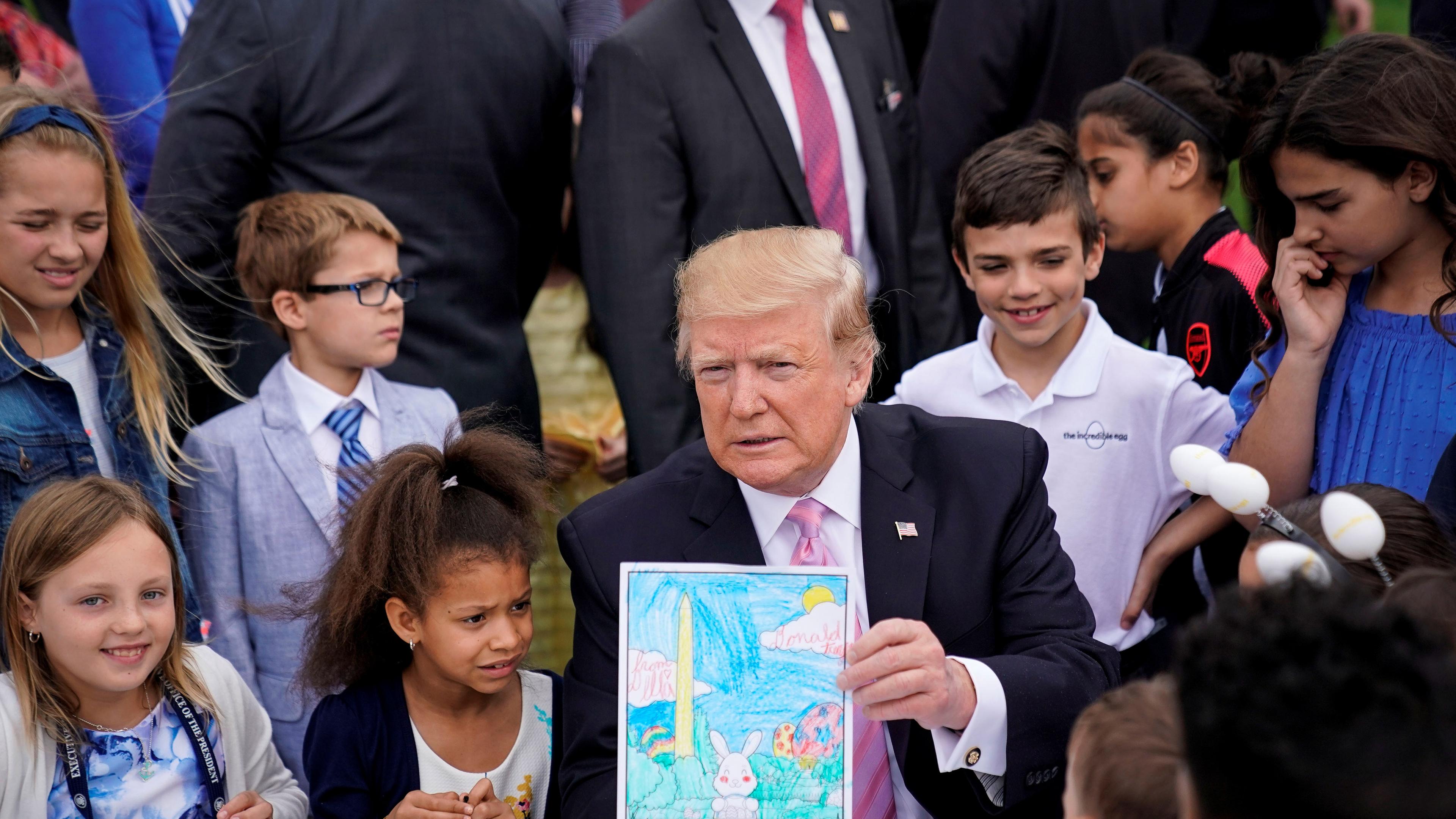 Trump hält ein gemaltes Bild für Militärmitglieder während des traditionellen Ostereierrollens in die Höhe in Washington am 22.04.2019