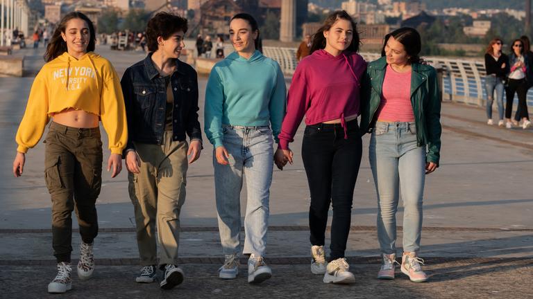 "The Gymnasts": Benedetta (Eva Iurlaro), Martina (Alessia De Falco), Nadia (Federica Cuomo), Carla (Giada Savi) und Anna (Giada Pirozzi) laufen nebeneinander dem Licht der untergehenden Sonne entgegen, während eine Brise vom Meer durch ihre Haare weht.
