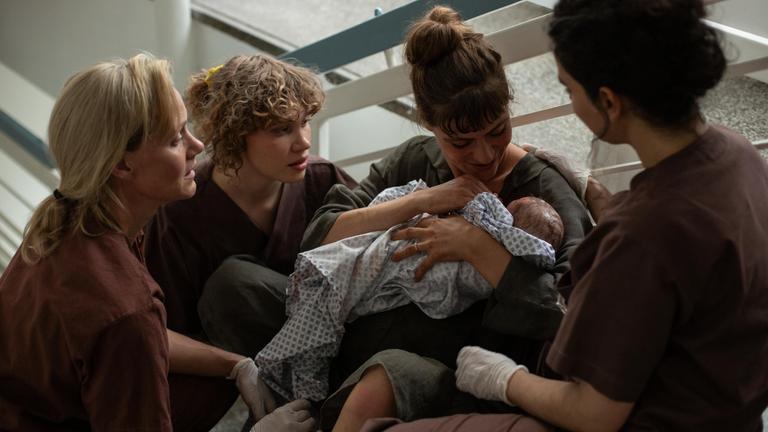 "PUSH - Weitermachen. Irgendwie": Anna Koch (Anna Schudt), Greta Malinger (Lydia Lehmann) und Nalan Arzouni (Mariam Hage) umgeben Valeria (Sophie Pfennigstorf), die im Treppenhaus des Krankenhauses sitzt und ihr neugeborenes Baby auf dem Arm hält.