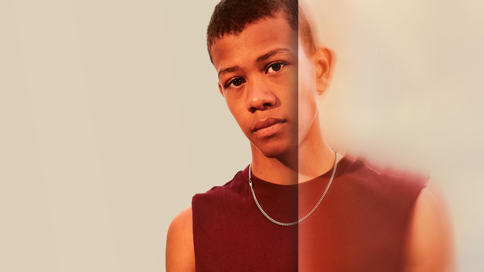 Benjamin schaut traurig in die Kamera. Der Hintergrund ist weiß.