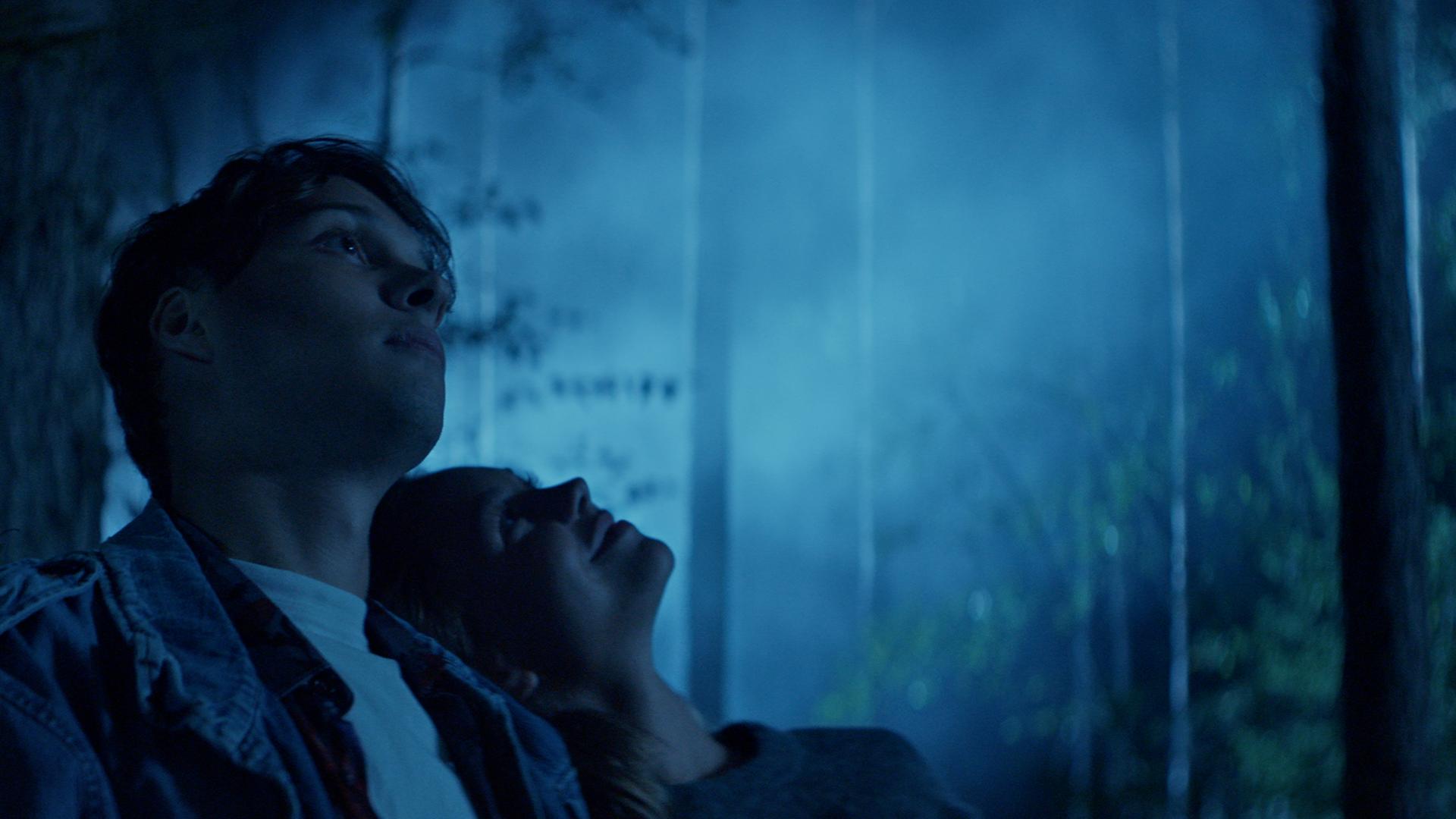 Ein junges Paar im dunklen Wald.