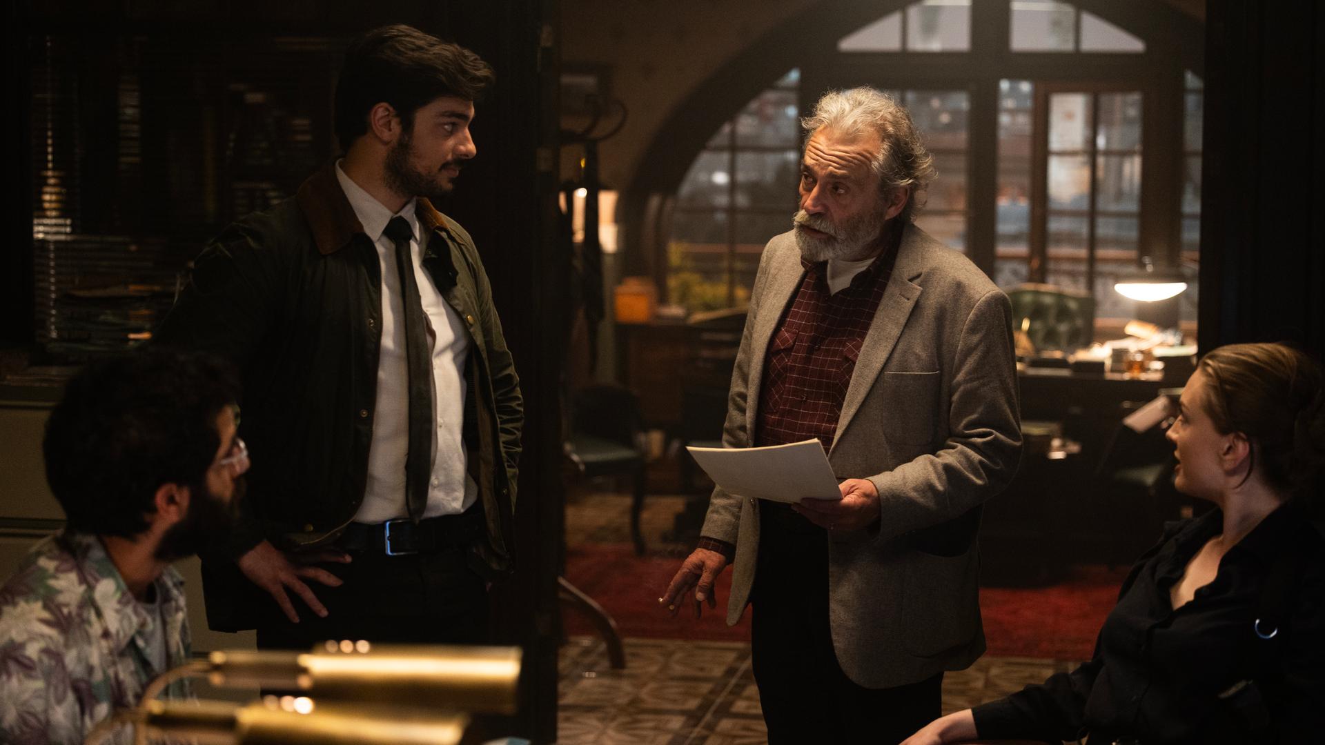 "Inspector Ikmen - Tod in Istanbul: Willkommen in Istanbul (1)": Inspector Ikmen (Haluk Bilginer), Mehmet Suleyman (Ethan Kai), Ayse Farsakoglu (Yasemin Kay Allen) und Tarik Sanver (Erol Afsin) stehen und sitzen in einem von elektrischem Licht beleuchteten Büro des Polizeireviers Istanbul.