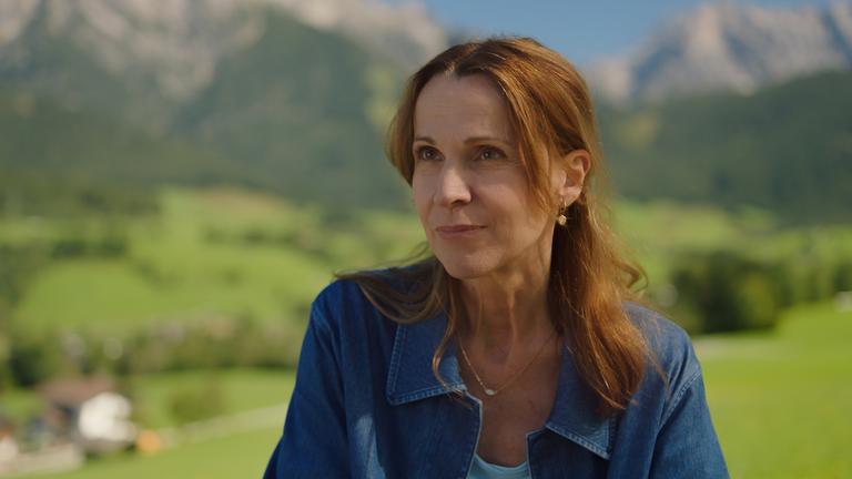 Dr. Johanna Maiwald (Doris Schretzmayer) blickt lächelnd in die Ferne.