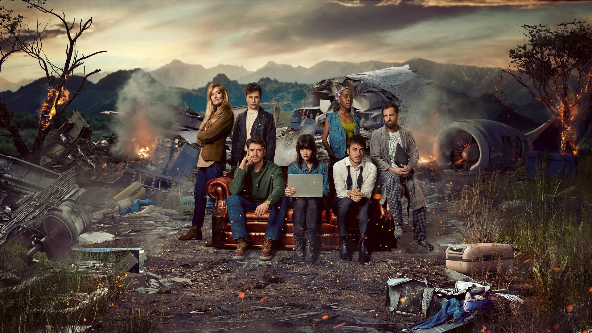 Das Rechercheteam "The Kollective" sitzt auf einer Couch zwischen Trümmern eines abgestürzten Flugzeugs.