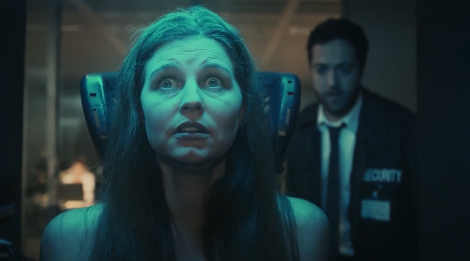 Laurence (Myriem Akheddiou) sitzt mit weit aufgerissenen Augen auf einem Stuhl. Sie sieht verängstigt aus. Um sie herum ist gedämpftes Licht und im Hintergrund steht ein Mann im Anzug, der sich ihr annähert.