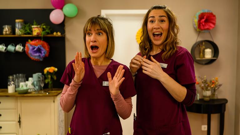 Von links: Rike Köhler (Isabell Horn), Betty Hertz (Henrike Hahn) "Bettys Diagnose - Eine von uns": Rike Köhler (Isabell Horn) und Betty Hertz (Henrike Hahn) stehen nebeneinander und jubeln begeistert, während sie in die Hände klatschen.