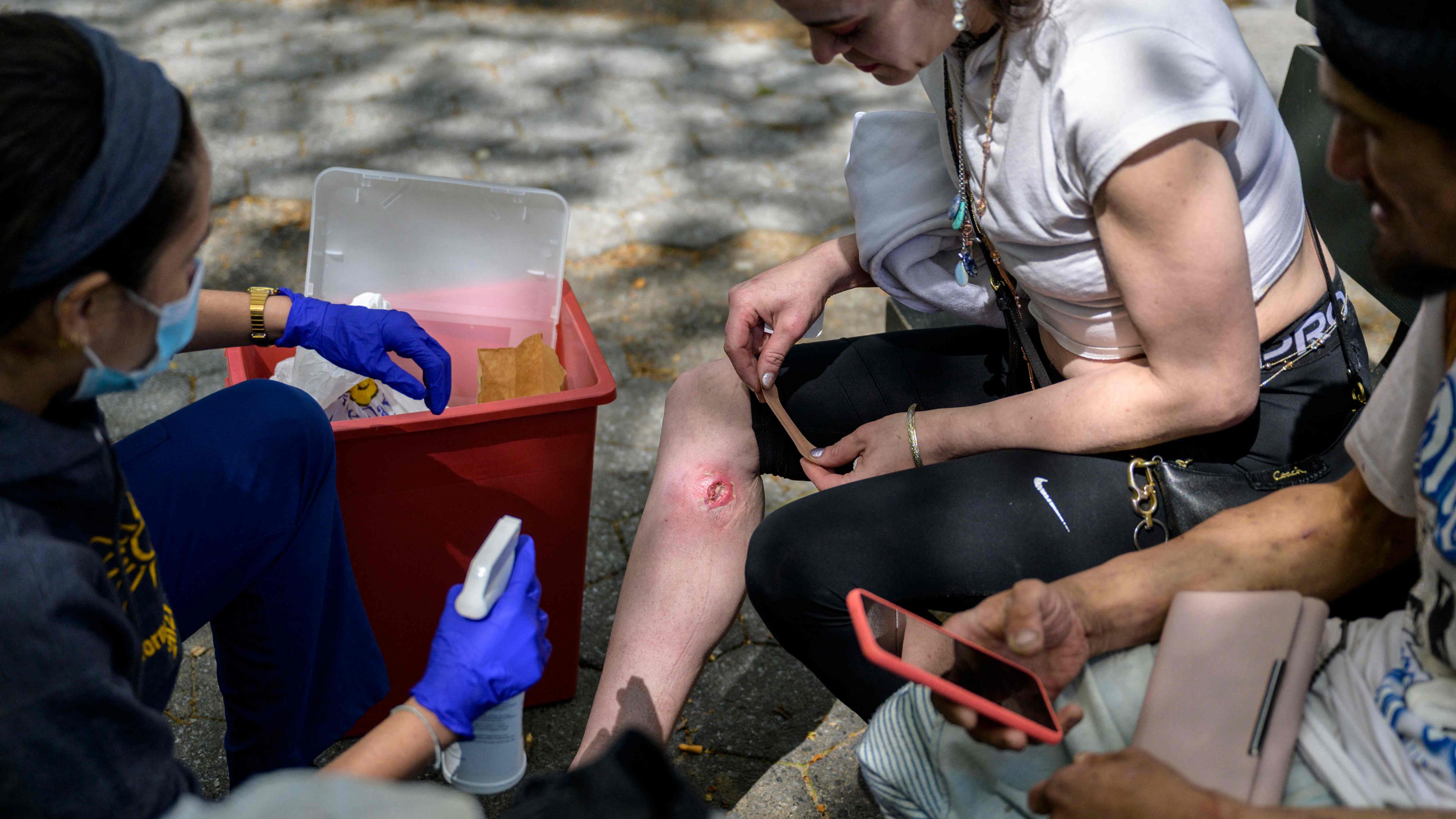 Eine Krankenpflegerin versorgt eine offene Wunde einer Tranq-Userin in einem Park im New Yorker Stadtteil Bronx.
