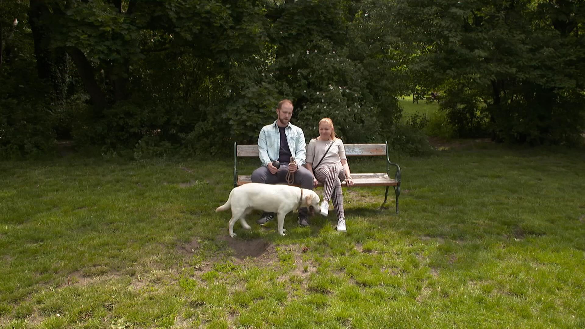 Ein Paar mit einem Hund auf einer Bank