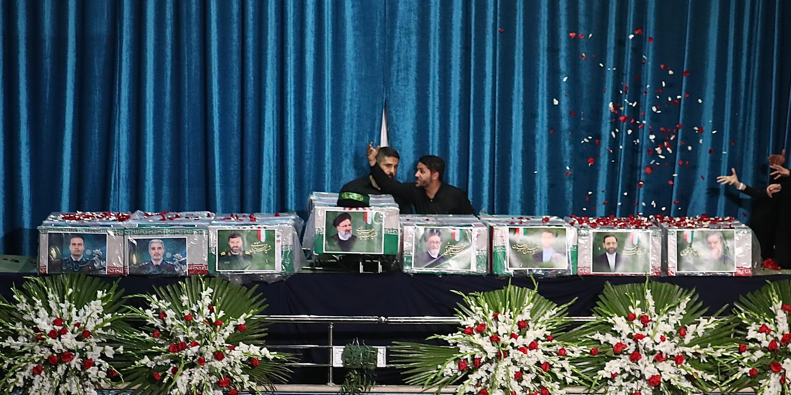 Iranische Beamte richten die Särge vor einer Trauerfeier für den verstorbenen iranischen Präsidenten Ebrahim Raisi, Irans Außenminister Amirabdollahian und sieben weitere Tote im Schrein von Imam Khomeini. 