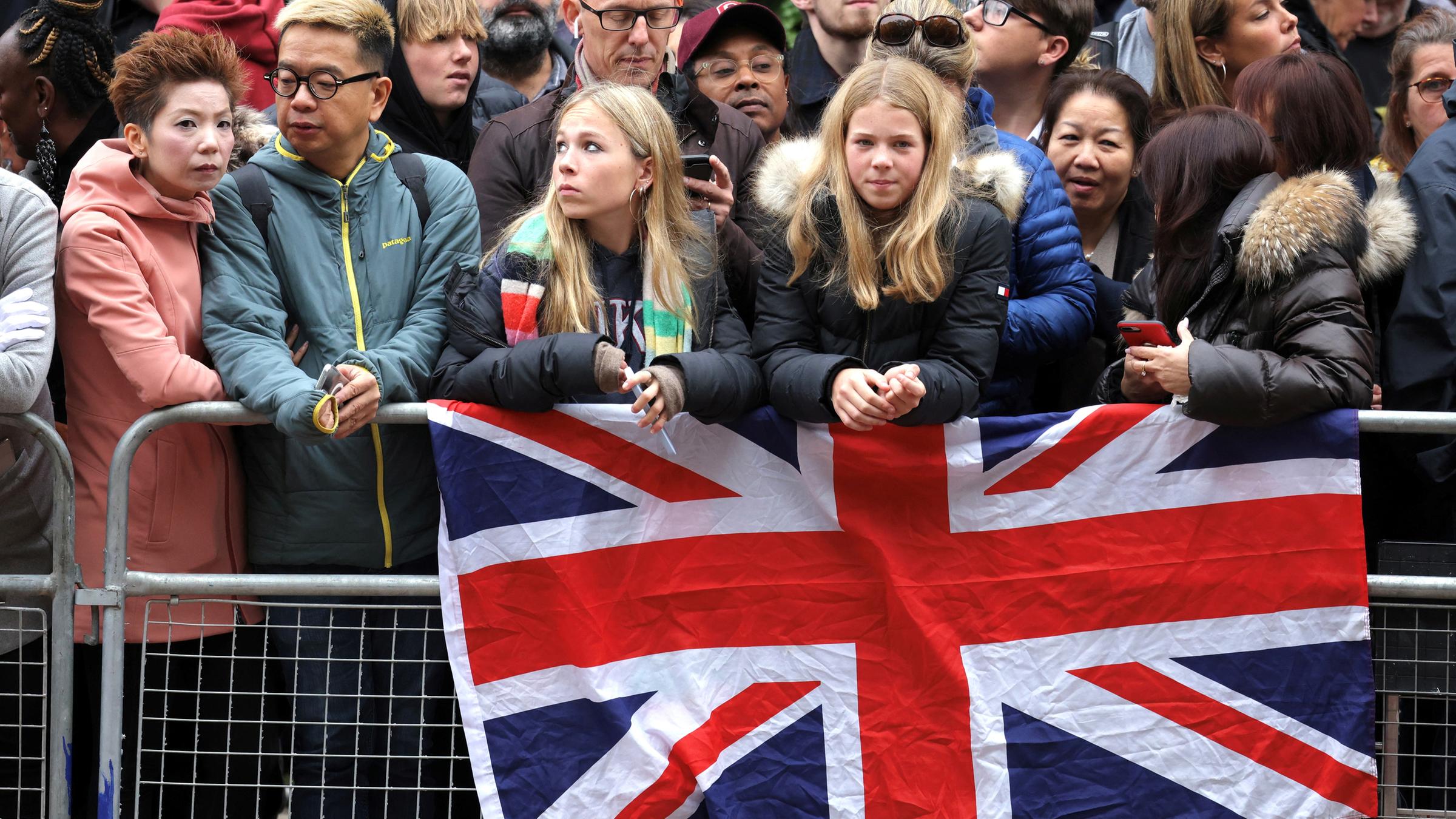Menschen stehen in London hinter einer Absperrung und warten auf den Trauerzug