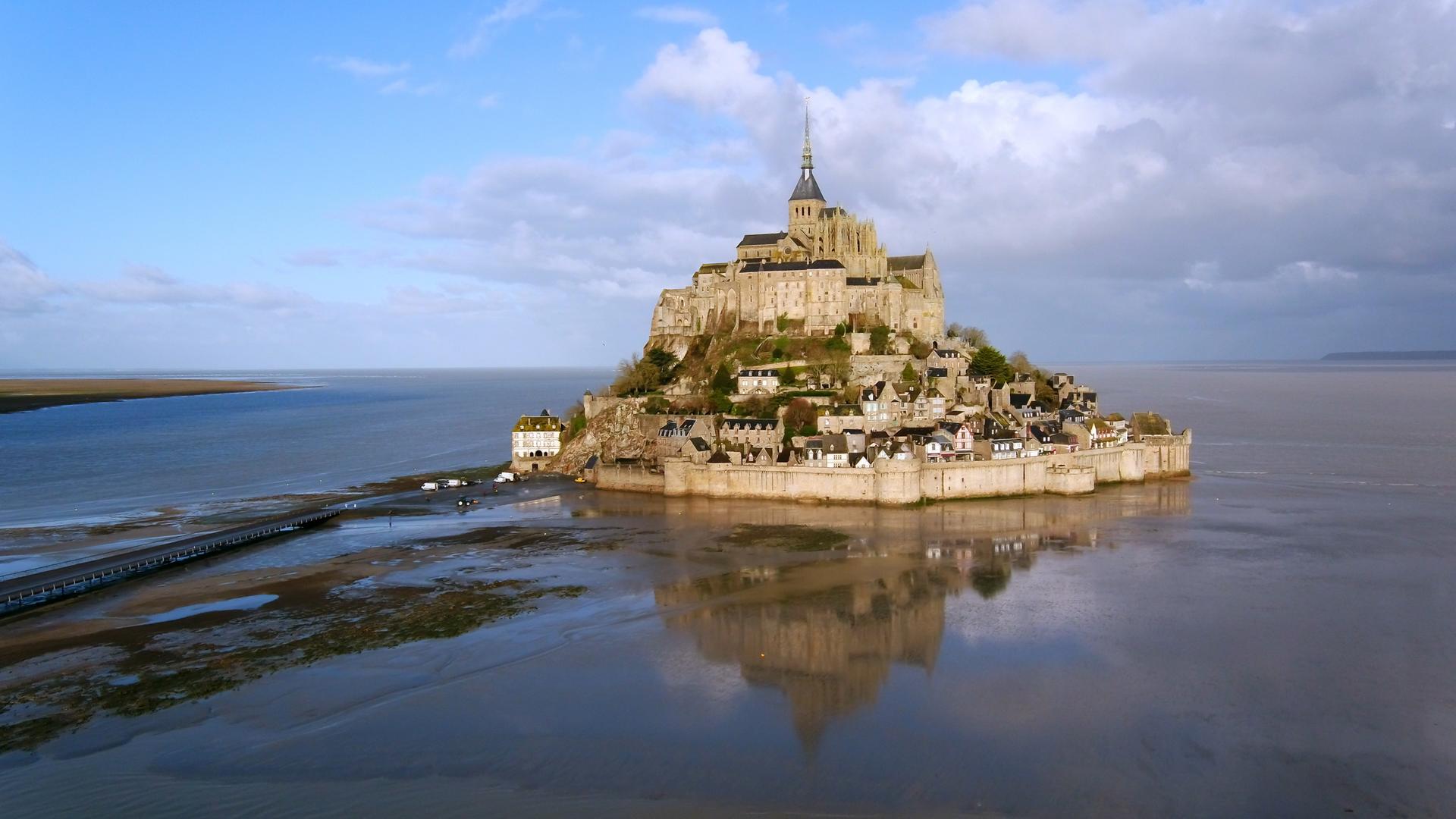 Traumorte - Die Normandie": Der Klosterberg Mont St. Michel umgeben vom Meer.