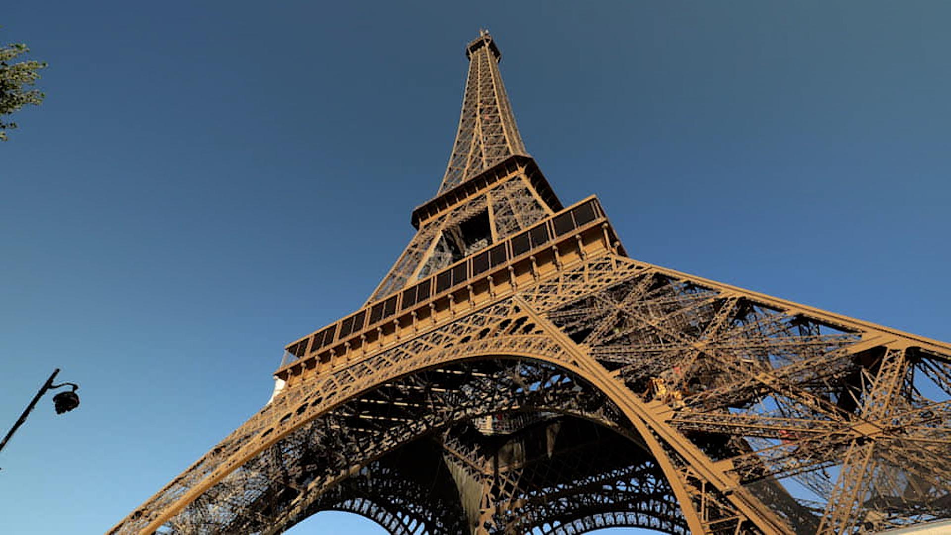 Der Eiffelturm vor blauem Himmel aus der Froschperspektive.