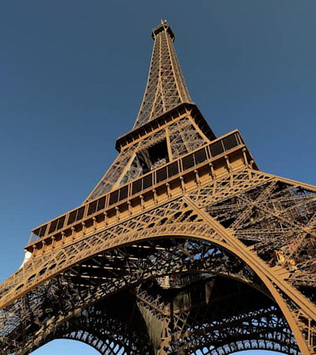 Der Eiffelturm vor blauem Himmel aus der Froschperspektive.