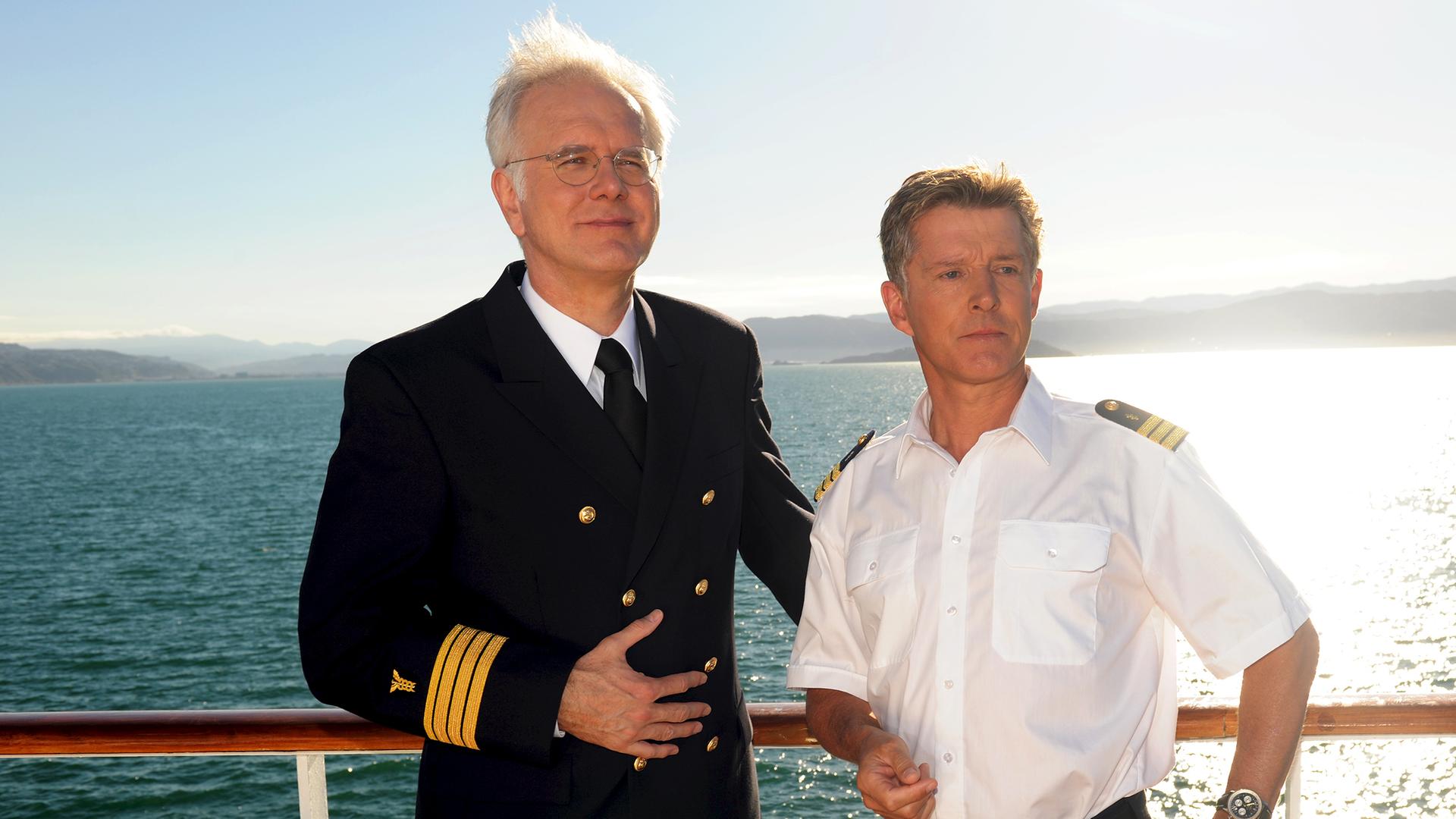 Oskar Schifferle (Harald Schmidt) und Dr. Sander (Nick Wilder) stehen an der Reling des Traumschiffes und schauen zufrieden in die Ferne. 
