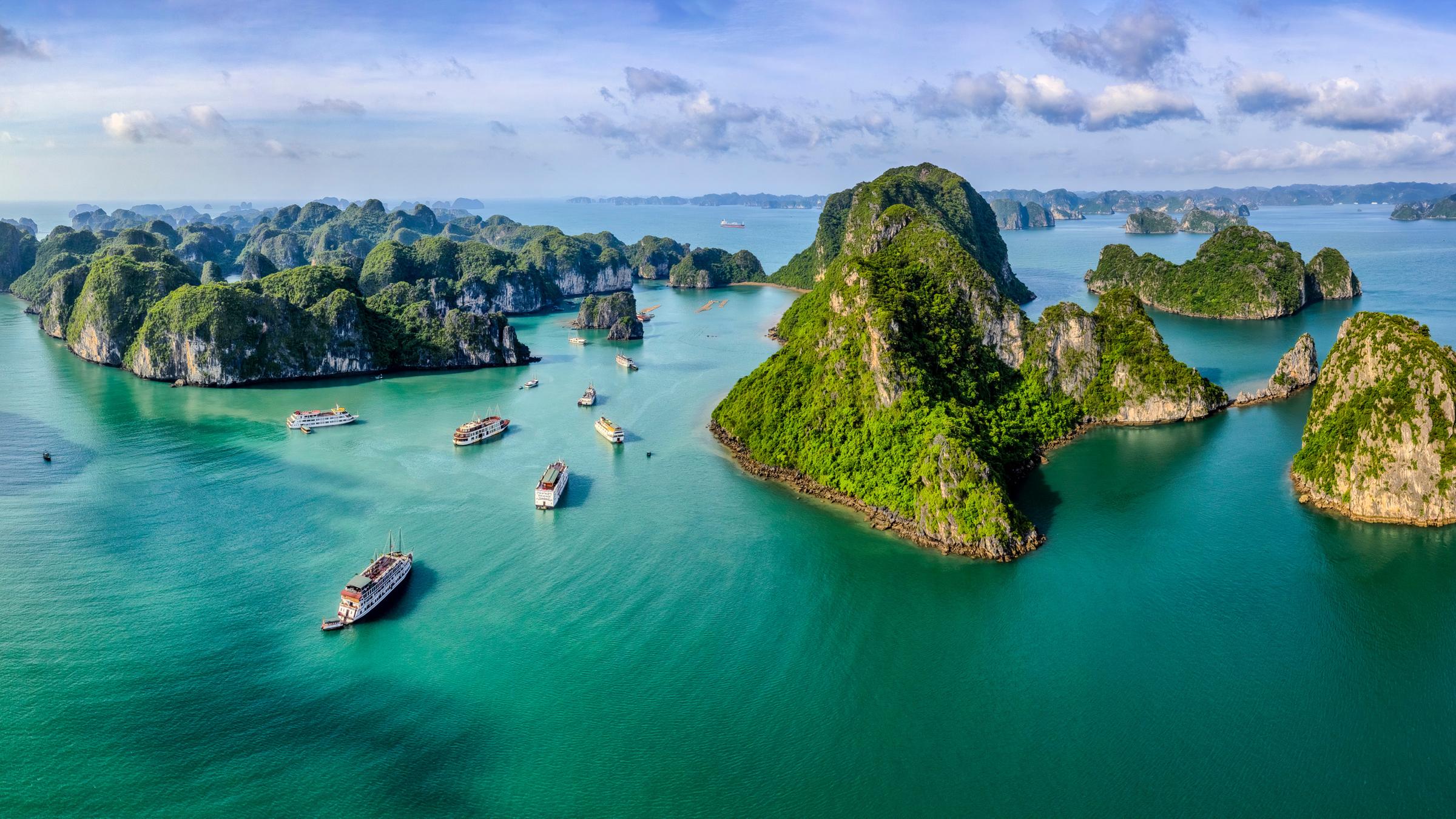 Kleine, grüne Inselchen ragen steil aus dem Meer.