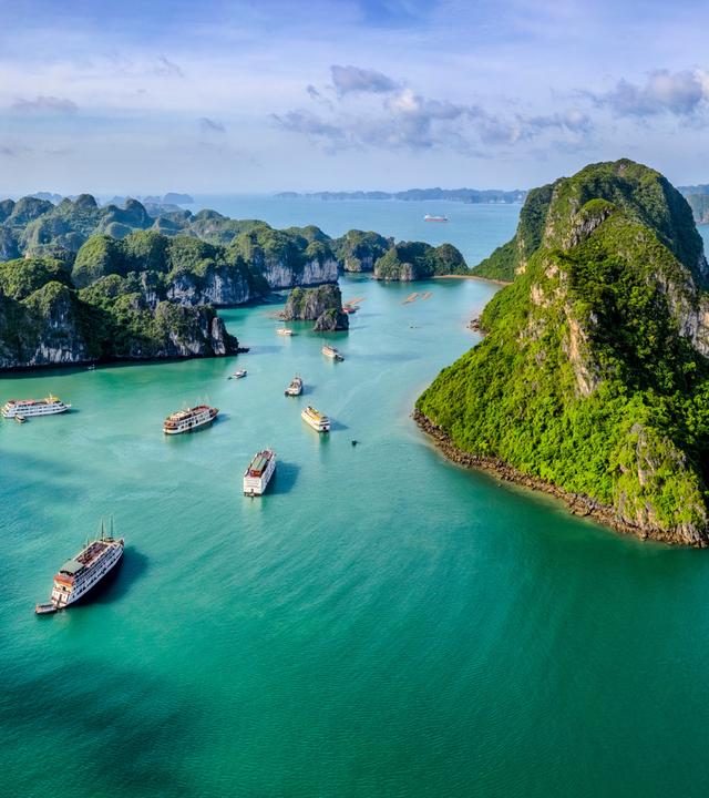 Kleine, grüne Inselchen ragen steil aus dem Meer.