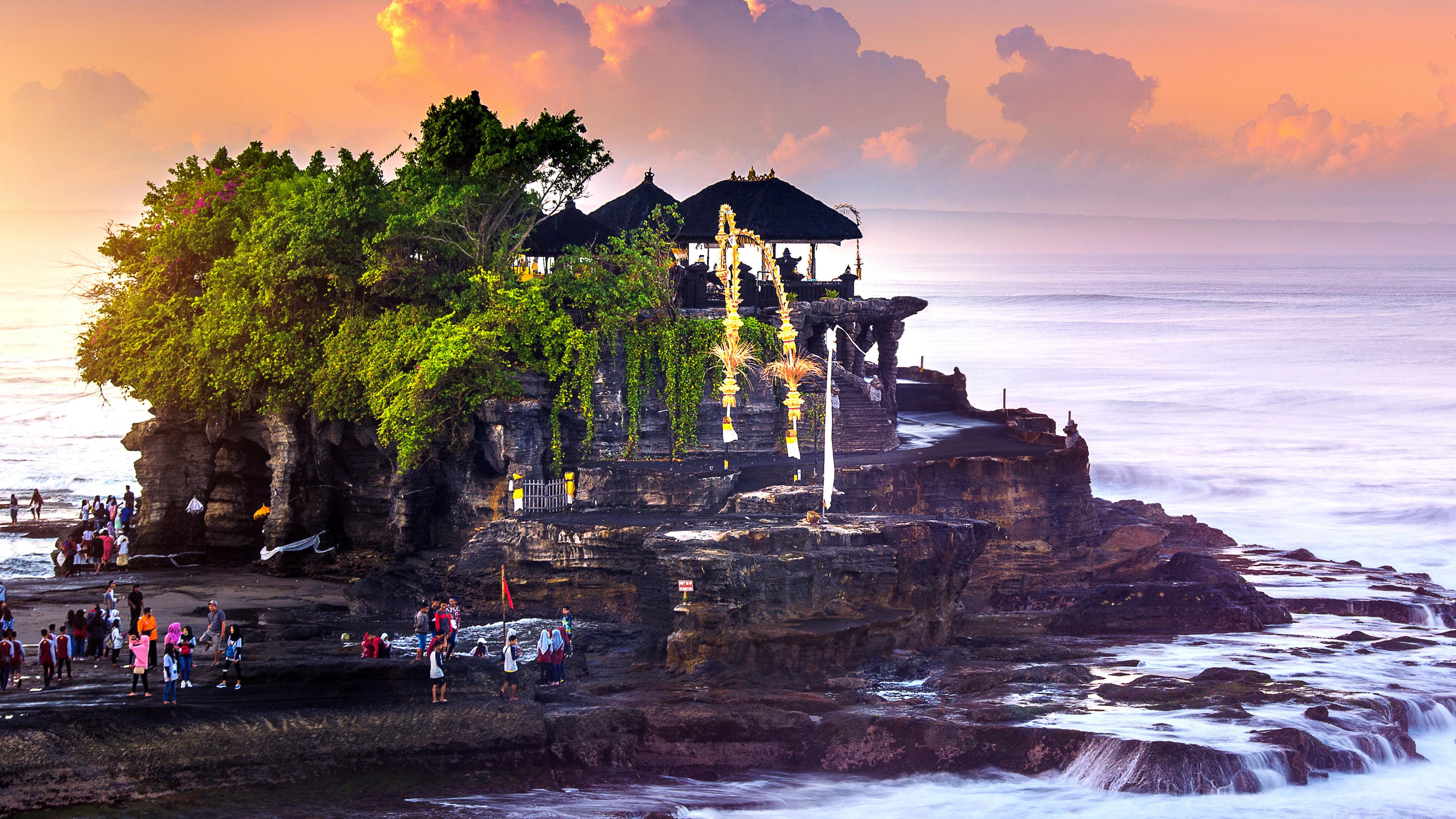 Ein Tempel steht auf einer kleinen Insel und ist vom Meer umspült.