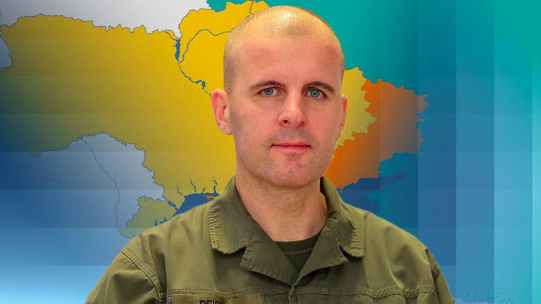 Oberst Reisner ist vor einer Karte der Ukraine abgebildet.