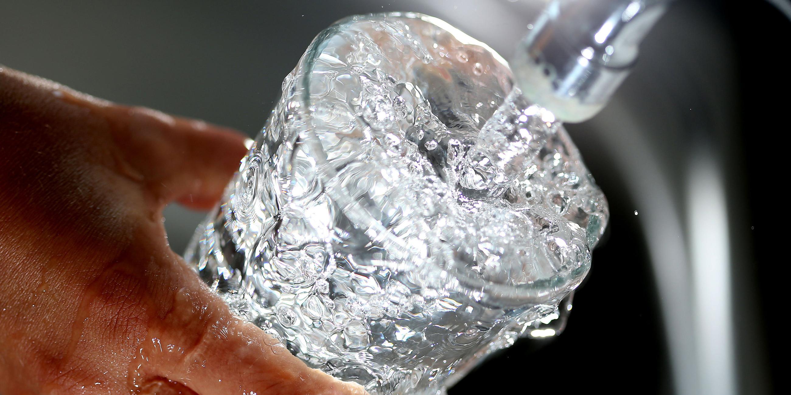 Trinkwasser läuft aus Wasserhahn in ein Glas