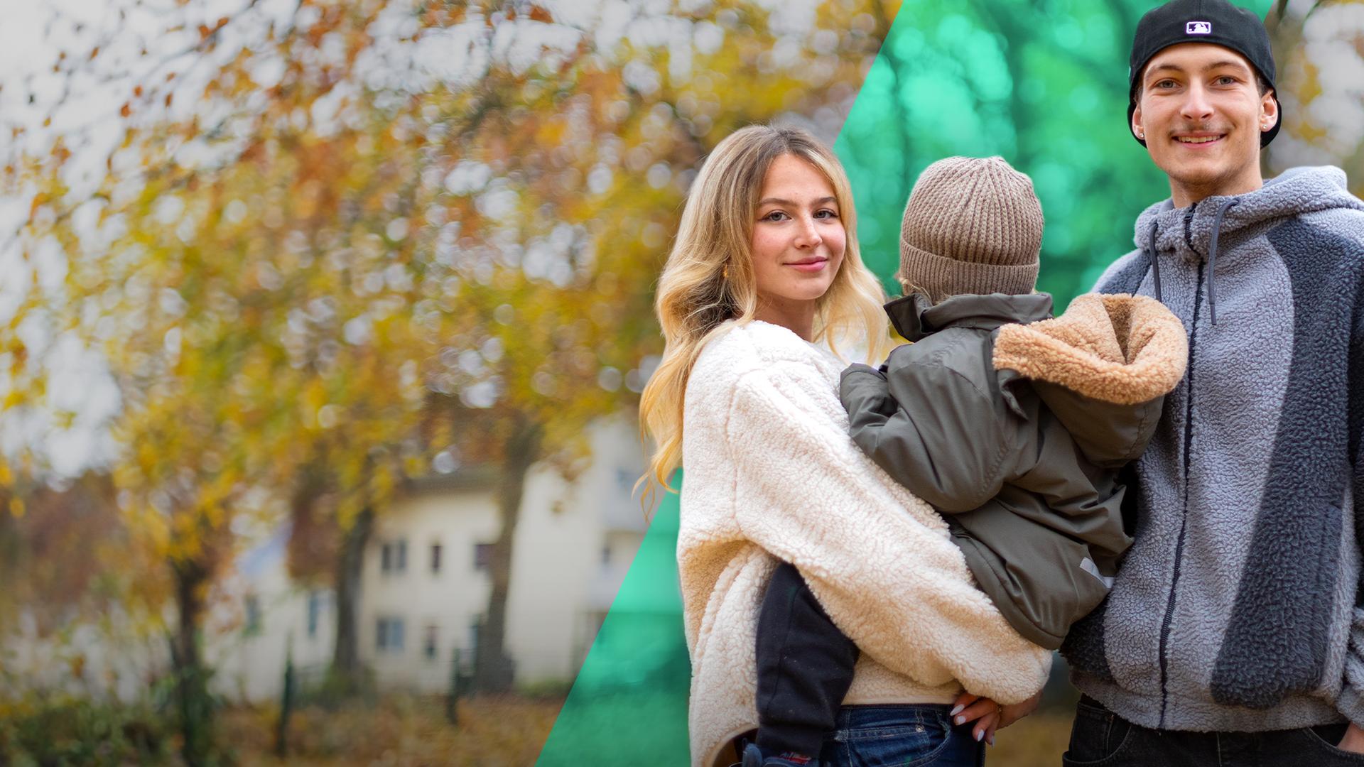 Eine junge Frau und ein junger Mann lächeln. Er trägt eine Mütze. Sie trägt ein kleines Kind auf dem Arm, das mit dem Gesicht nach hinten schaut.
