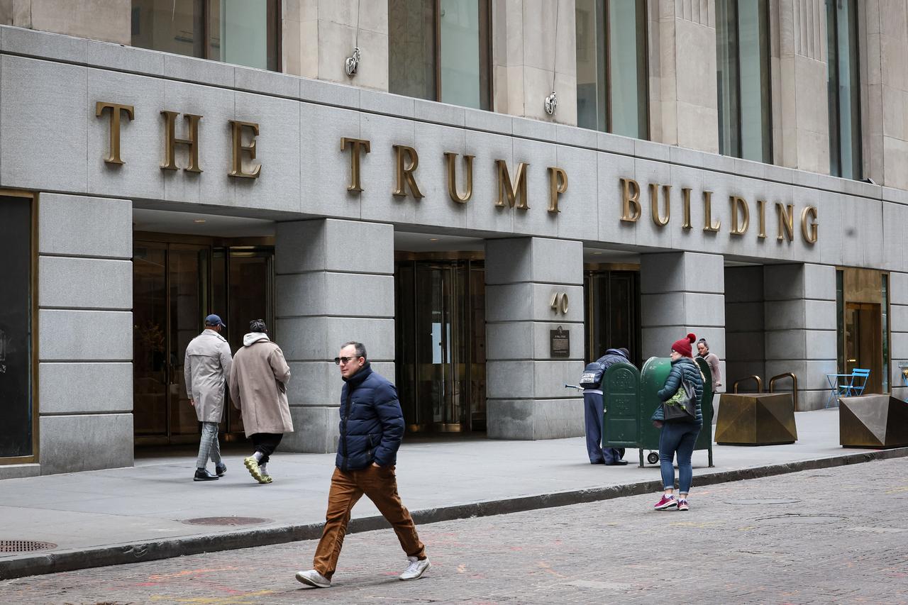 Menschen gehen vor dem Trump Building 40 Wall Street im Finanzdistrikt in New York City spazieren