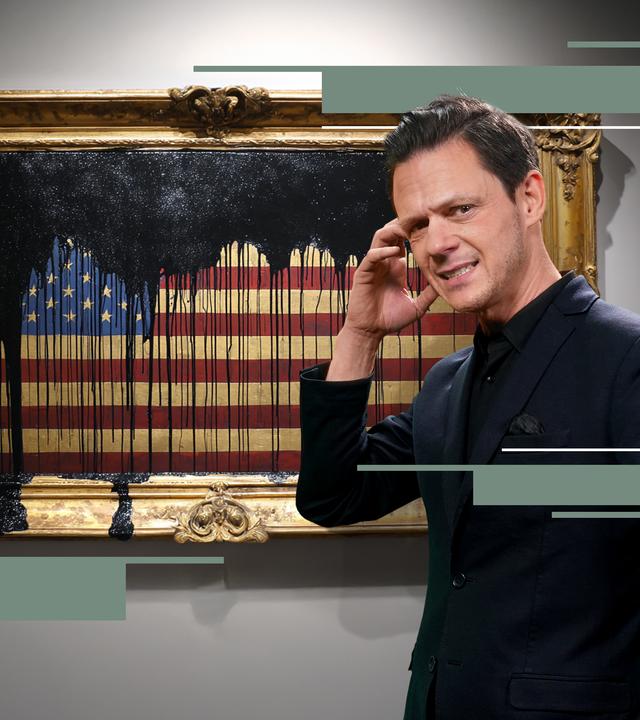 Jo Schück mit kritischem Blick vor amerikanischer Flagge in Bilderrahmen