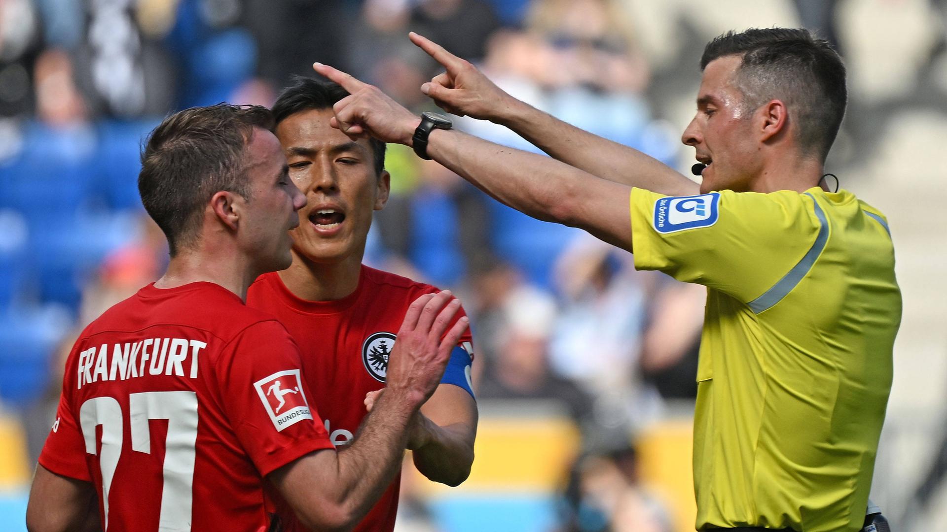 Mario Götze Goetze (Eintracht Frankfurt) und Makoto Hasebe (Eintracht Frankfurt) diskutieren mit Schiedsrichter Harm Osmers.