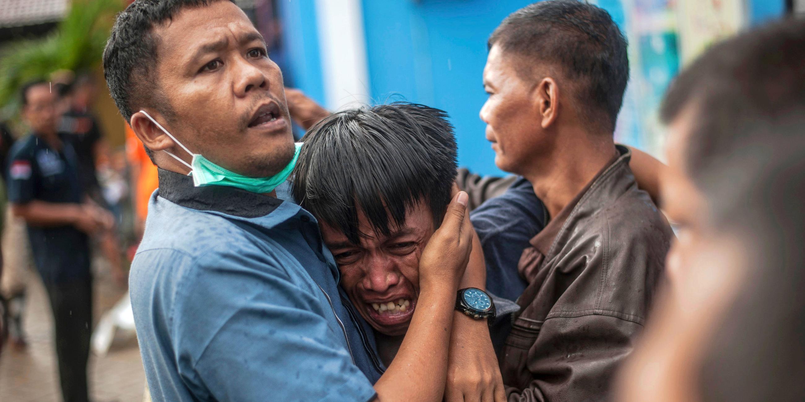 Männer trauern nach dem Tsunami in Carita (Indonesien), aufgenommen am 24.12.2018
