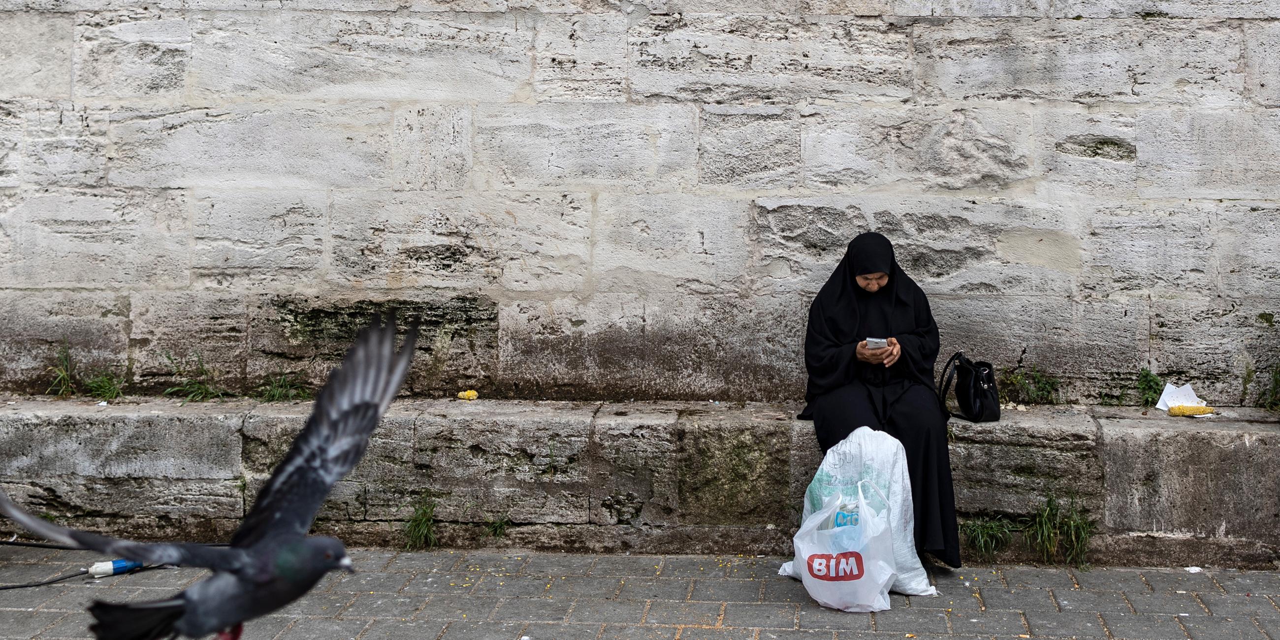 Eine Frau sitzt am Straßenrand in der Türkei.