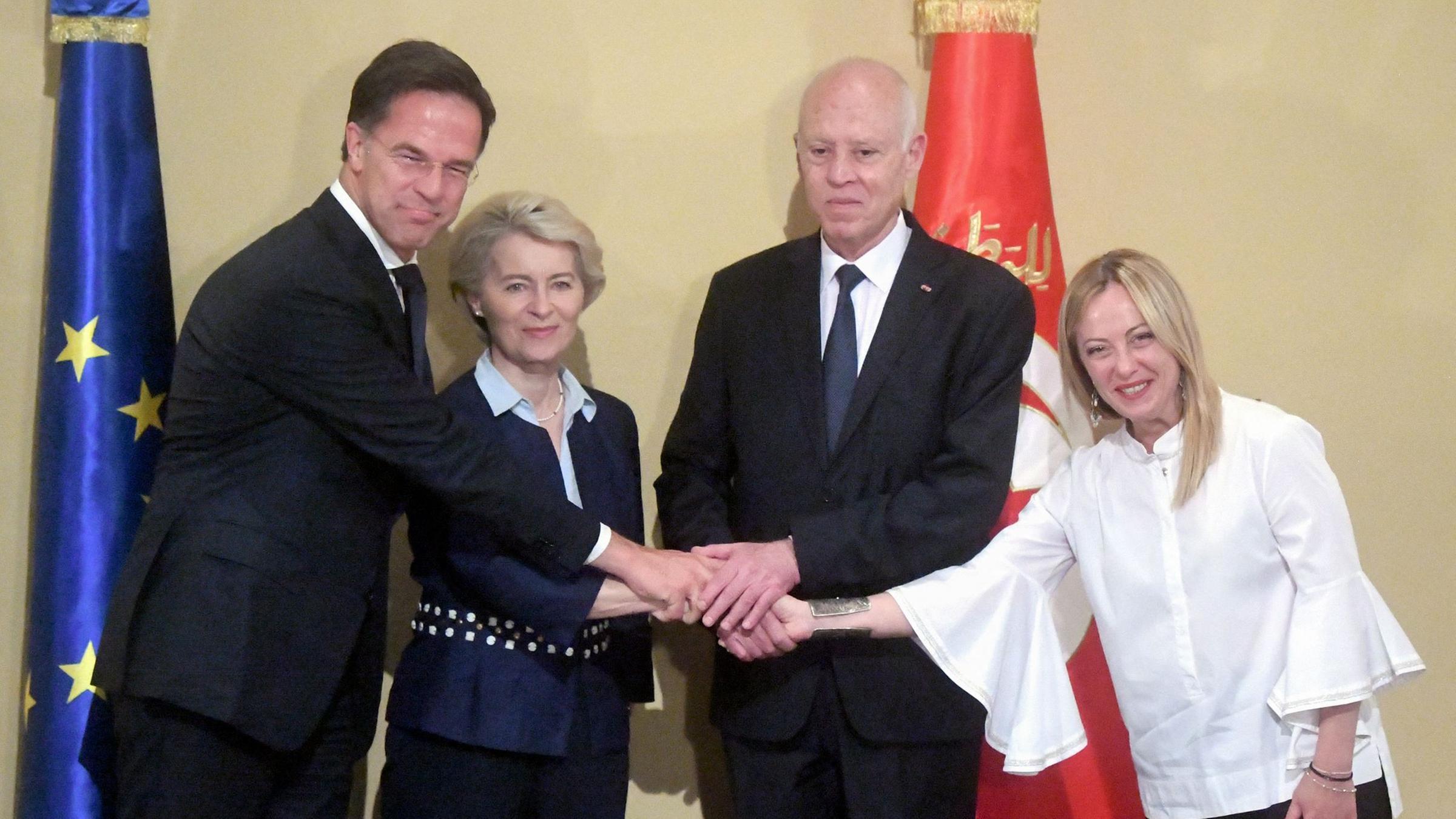 Mark Rutte, Ursula Von der Leyen, Kais Saied und Giorgia Meloni geben sich gemeinsam die Hand.