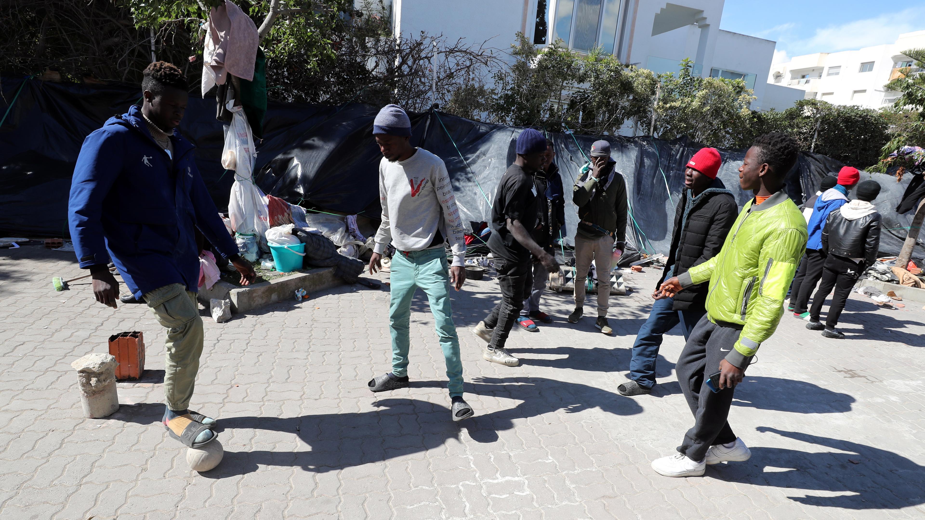 Junge Männer aus Subsahara-Afrika spielen Fußball vor der Zentrale der Internationalen Organisation für Migration (IOM) in Tunis.