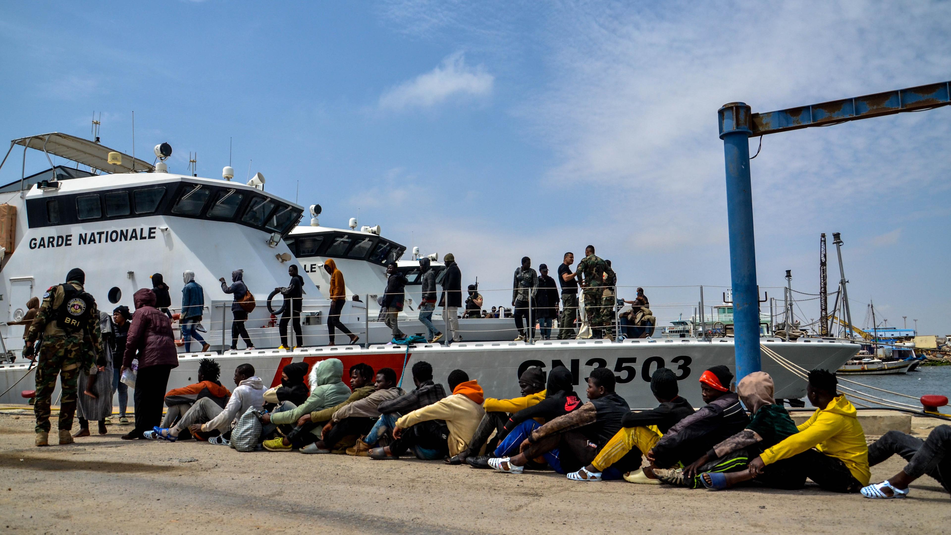 Migranten, die von der tunesischen Marine aufgegriffen wurden, warten am Hafen