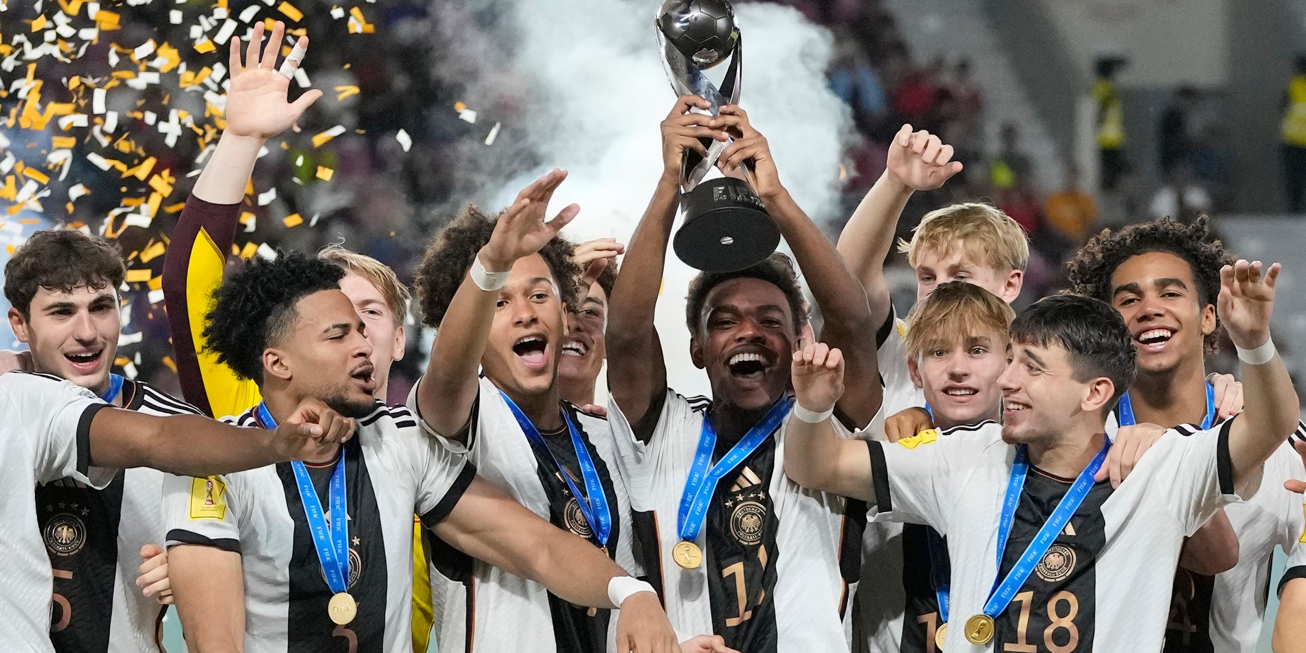 Die deutsche Mannschaft feiert auf dem Podium mit ihrem Pokal nach dem Sieg über Frankreich im Endspiel der U-17-Fußballweltmeisterschaft in Indonesien am 02.12.2023.