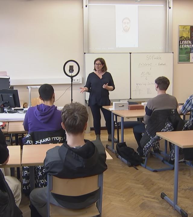 Übergangslotsin spircht vor Schulklasse.