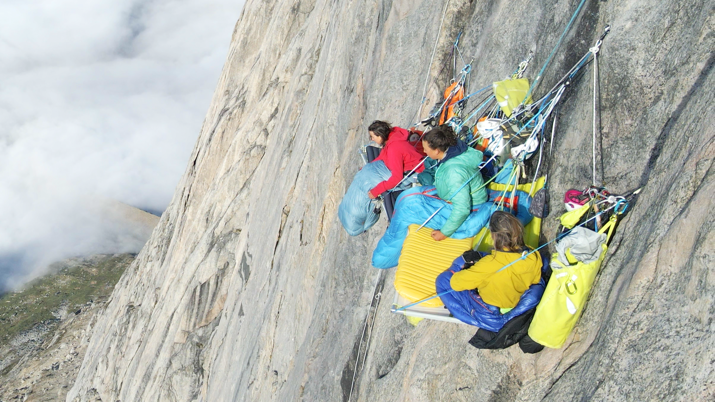 Eine Gruppe Kletterinnen auf einem sogenannten Portaledge in einer Steilwand