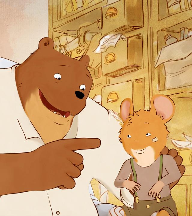 Im Wohnzimmer sitzt Ernest auf seinem Sessel. Er hat Mandarine auf dem Schoß, schaut sie freundlich an und zeigt mit seinem Zeigefinger nach vorne. Mandarine hört ihm aufmerksam zu und schaut Ernest dabei an.