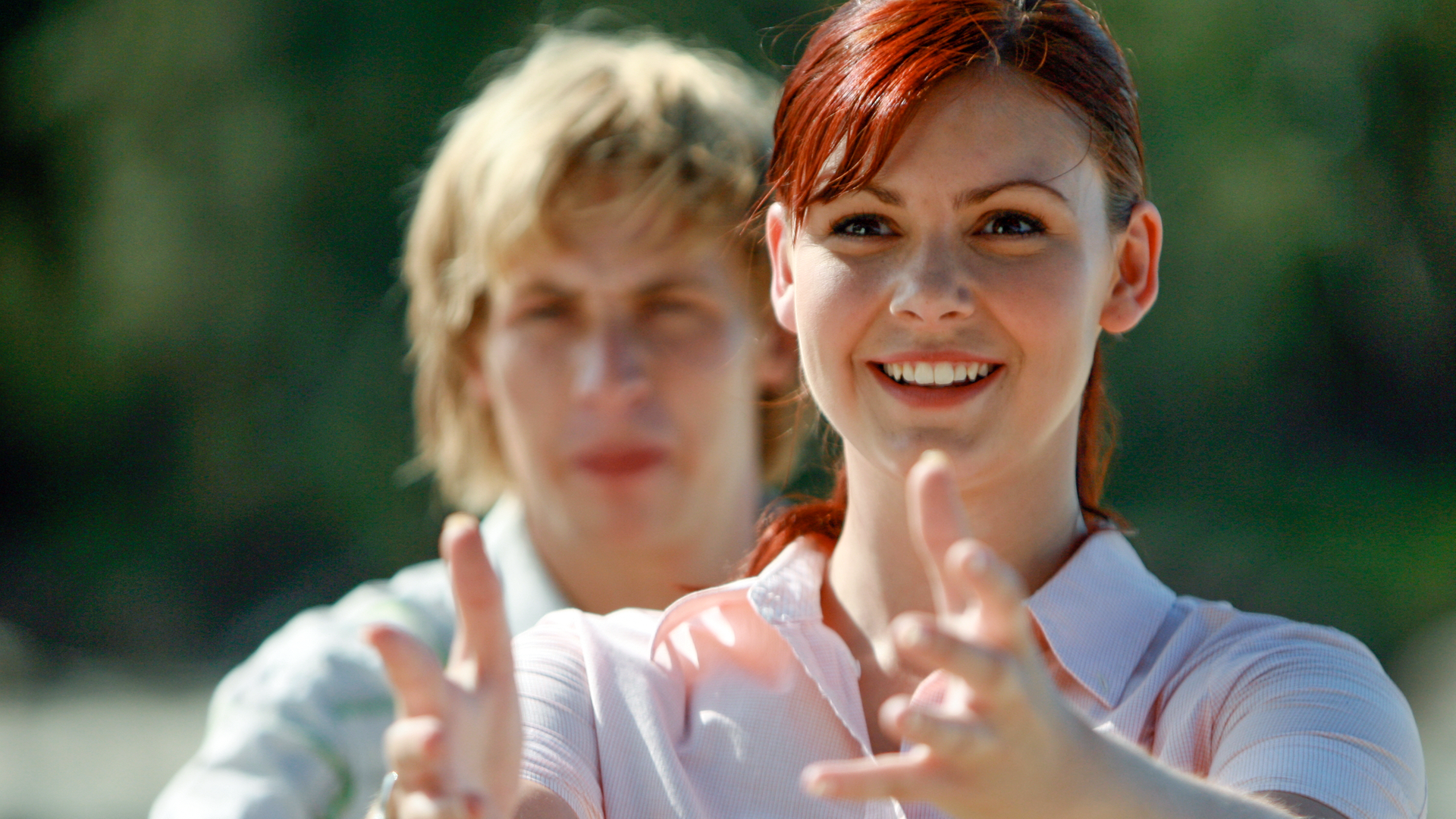 Charlotte steht vorne. Lewis im Hintergrund. Sie zeigt Lewis etwas.