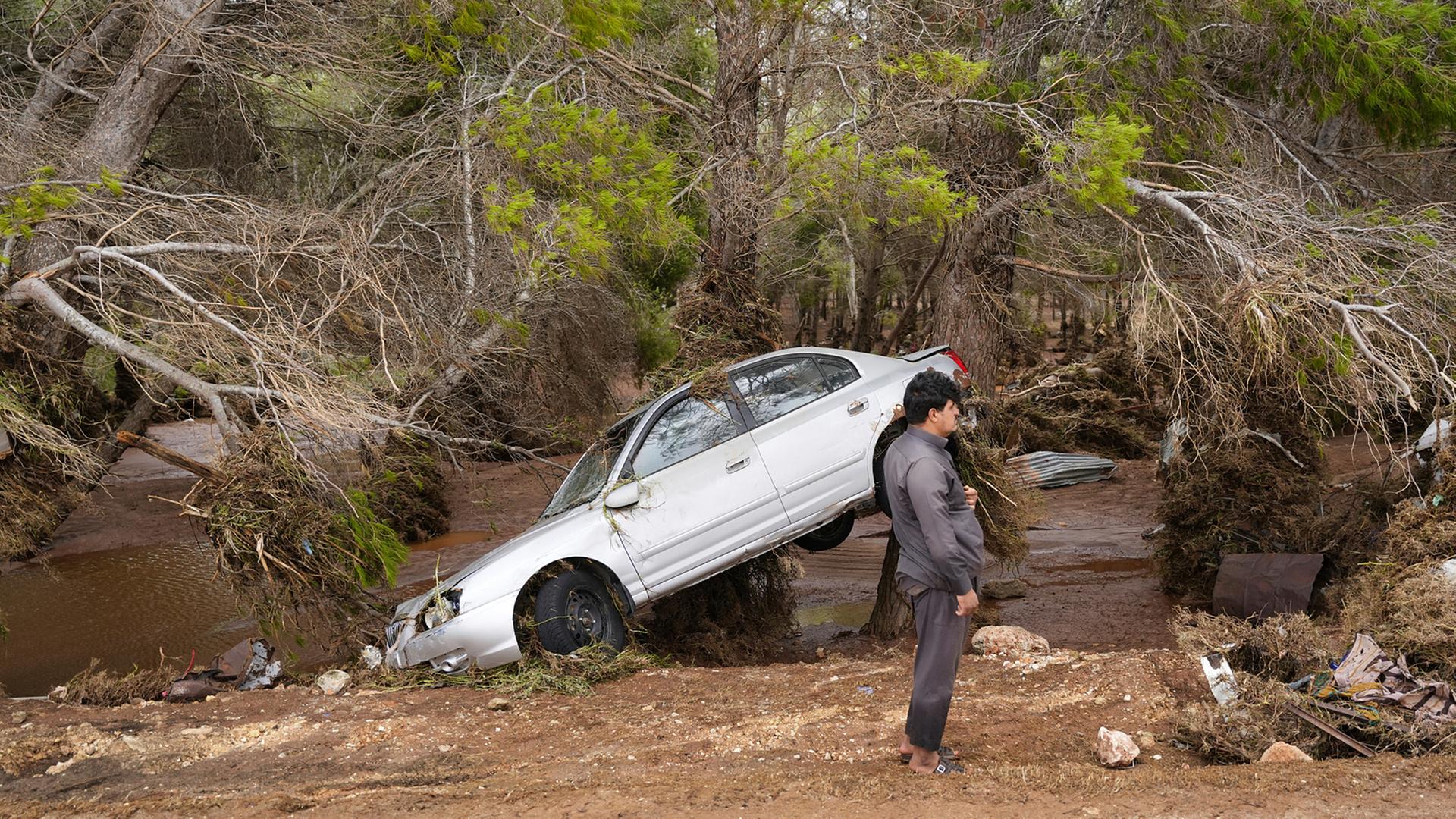 Ein Auto hängt teilweise in den Bäumen, nachdem es von den Fluten in Darna, Libyen, mitgerissen wurde, aufgenommen am 11.09.2023.