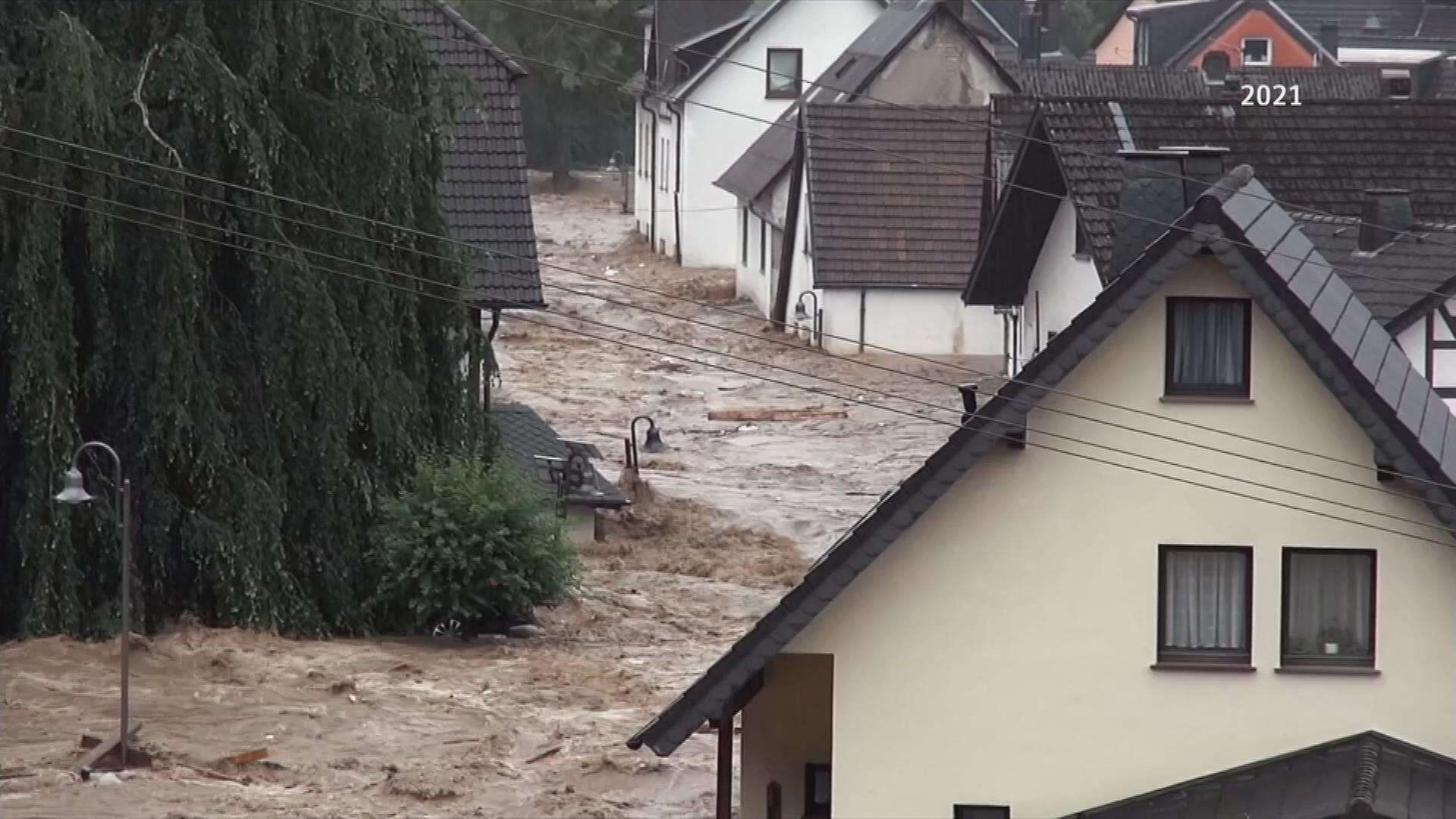 Hochwasser fließt durch Wohngebiet.