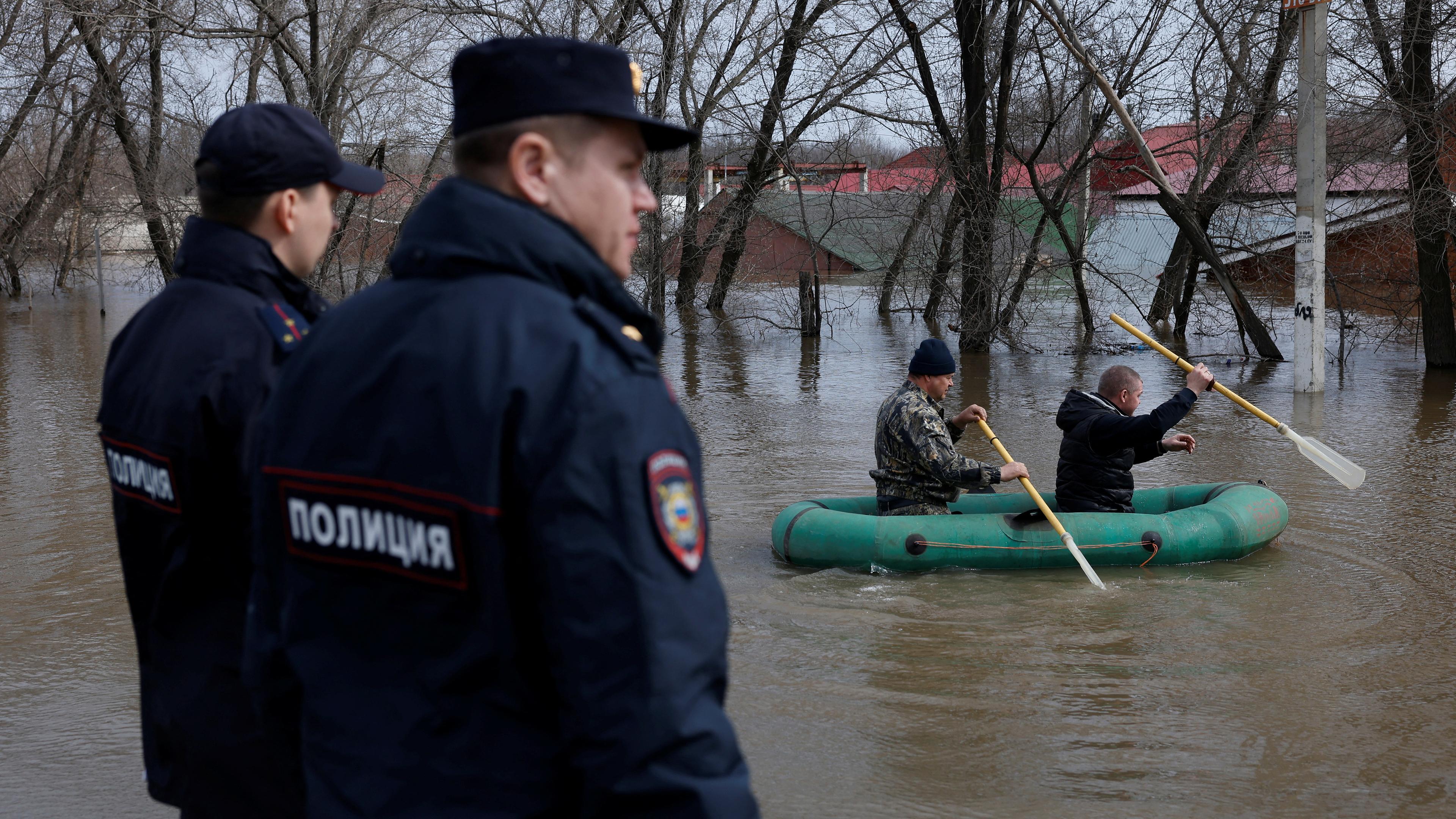 Menschen paddeln mit einem Schlauchboot durch ein überflutetes Wohngebiet in Orenburg, Russland