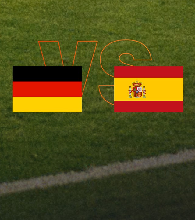 Deutsche und spanische Flagge vor grünem Rasen.