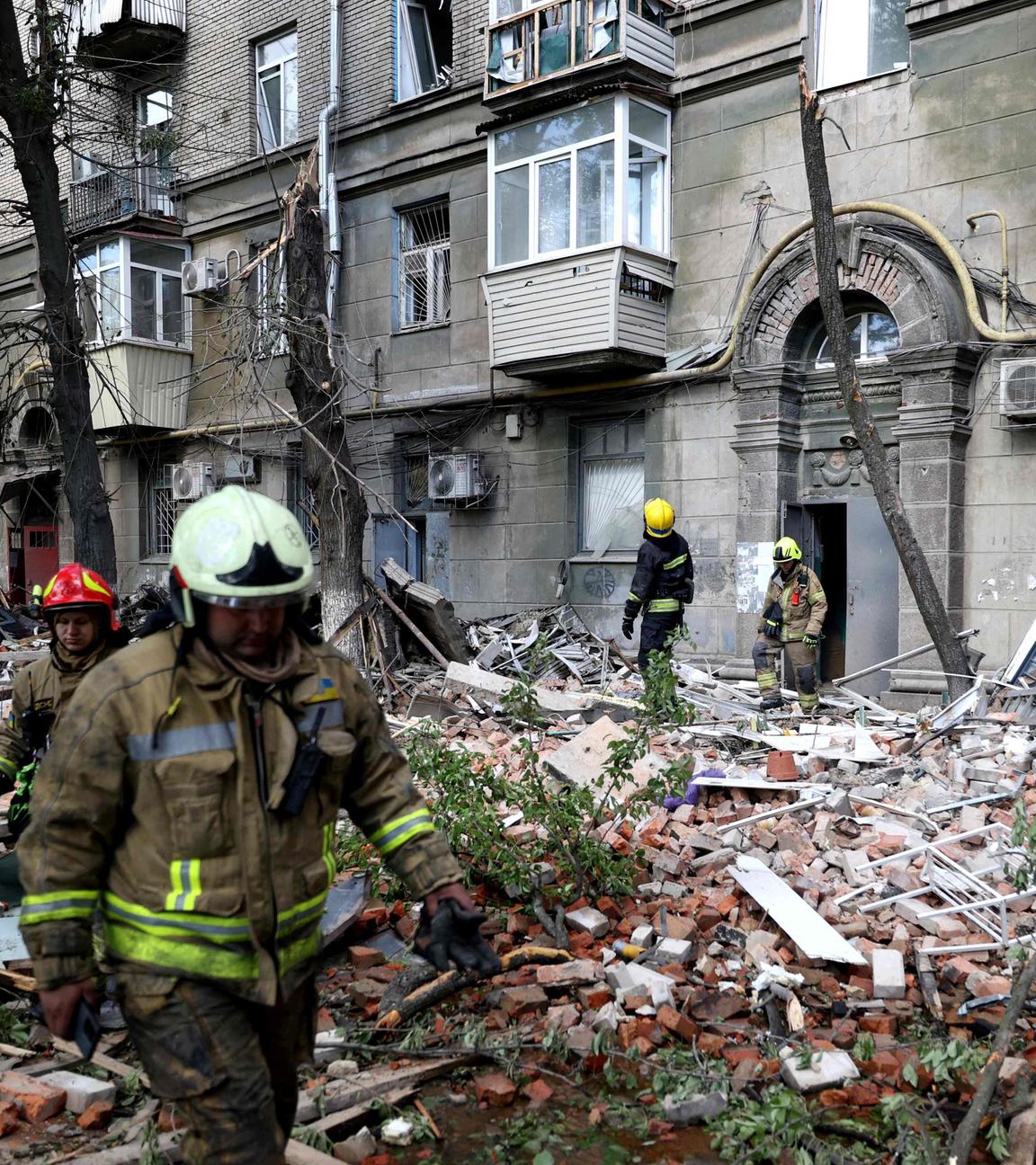 Ukrainische Rettungskräfte vor einem beschädigten Gebäude