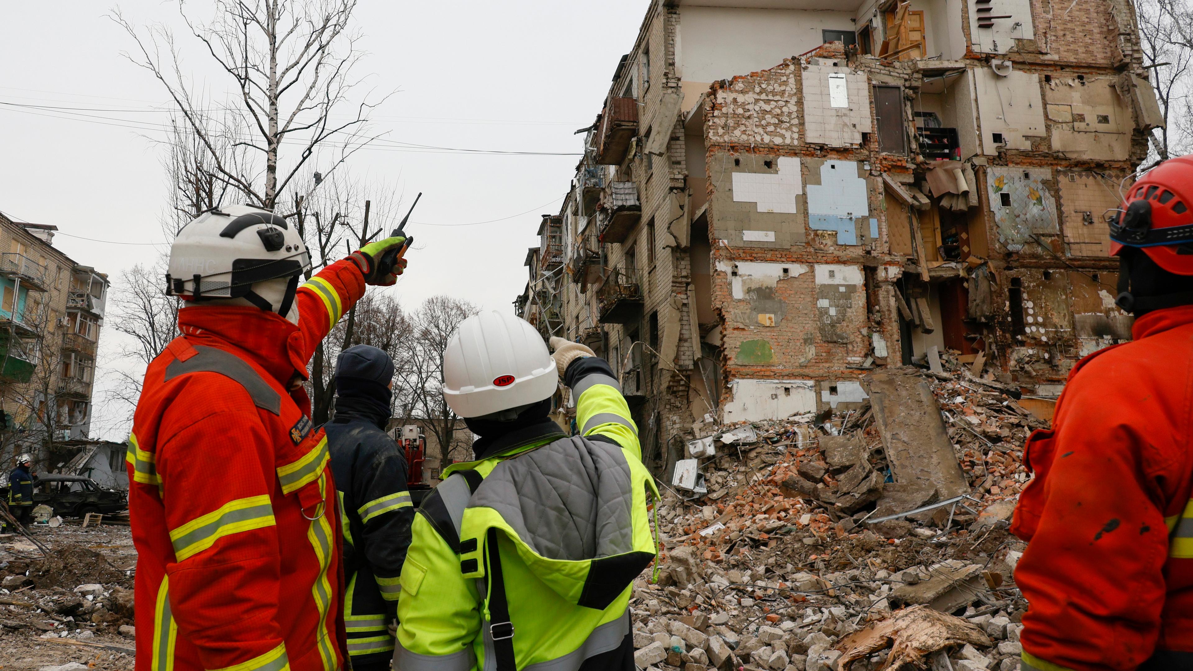 Ukrainische Arbeiter beseitigen Trümmer beschädigter Gebäude am Ort eines Raketenangriffs in Charkiw