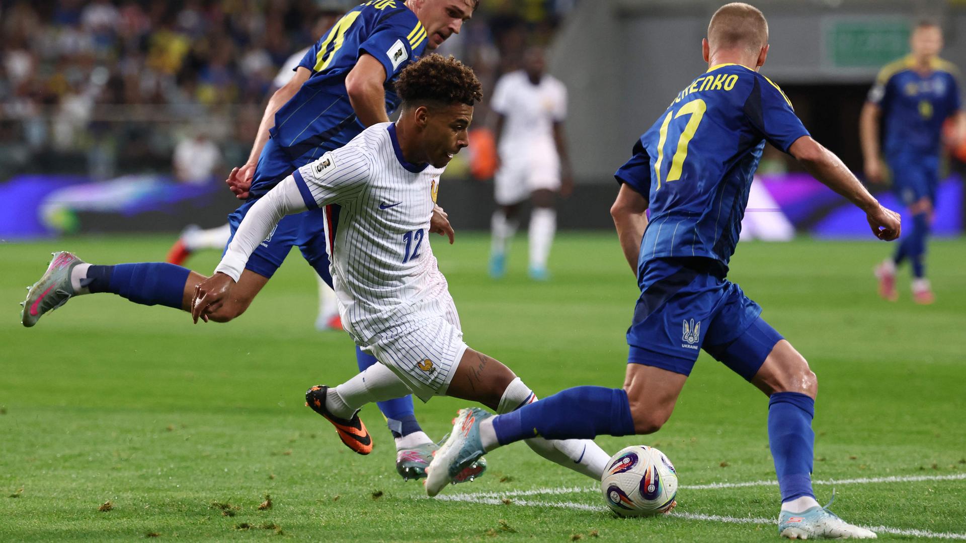 Désiré Doué (Mitte) setzt zum Schuss an, der Ukrainer Oleksandr Zinchenko will blocken.