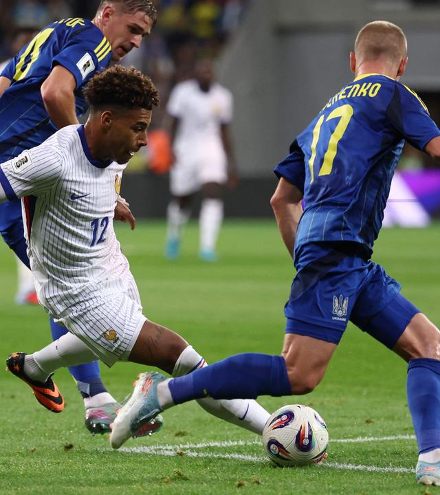 Désiré Doué (Mitte) setzt zum Schuss an, der Ukrainer Oleksandr Zinchenko will blocken.