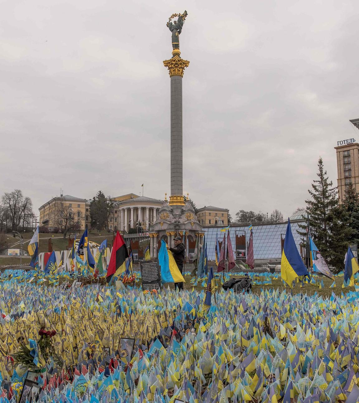A man sets a Ukrainian flag next to flags bearing symbols and colours of Ukraine to commemorate fallen Ukrainian army soldiers at Independence Square in Kyiv, on February 24, 2024, on the second anniversary of Russia's invasion of Ukraine.