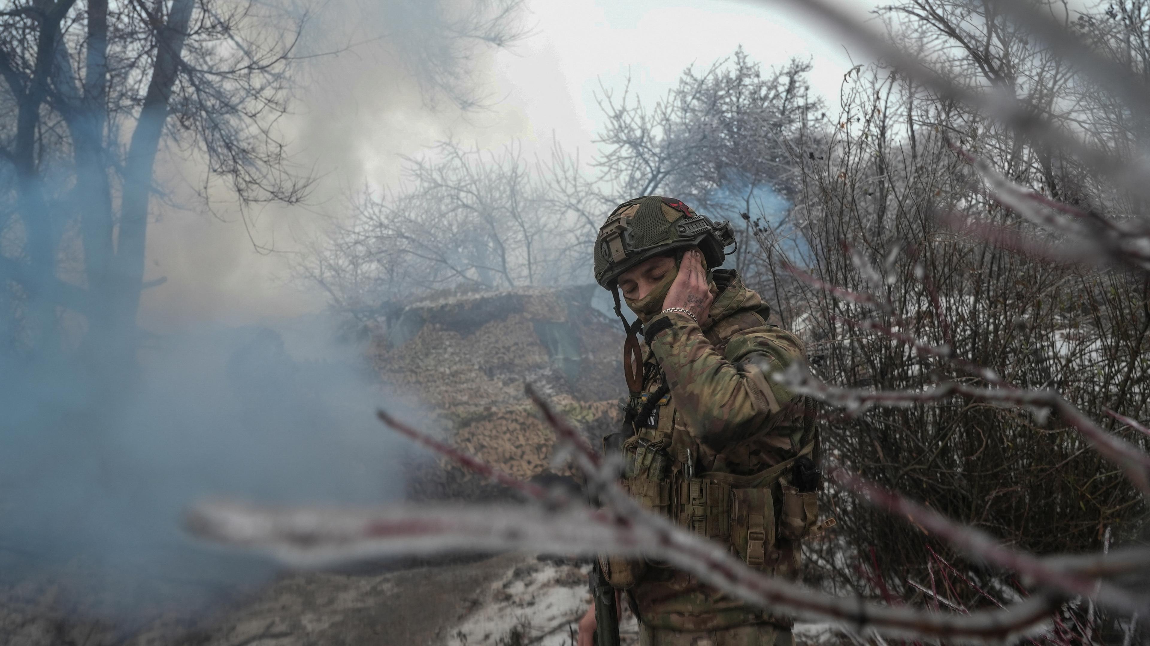 Ein ukrainischer Soldat hält sich das Ohr zu, während eine Panzerhaubitze 2S1 Gvozdika auf russische Truppen an der Frontlinie in der Nähe der Stadt Bakhmut feuert am 15.12.2023.