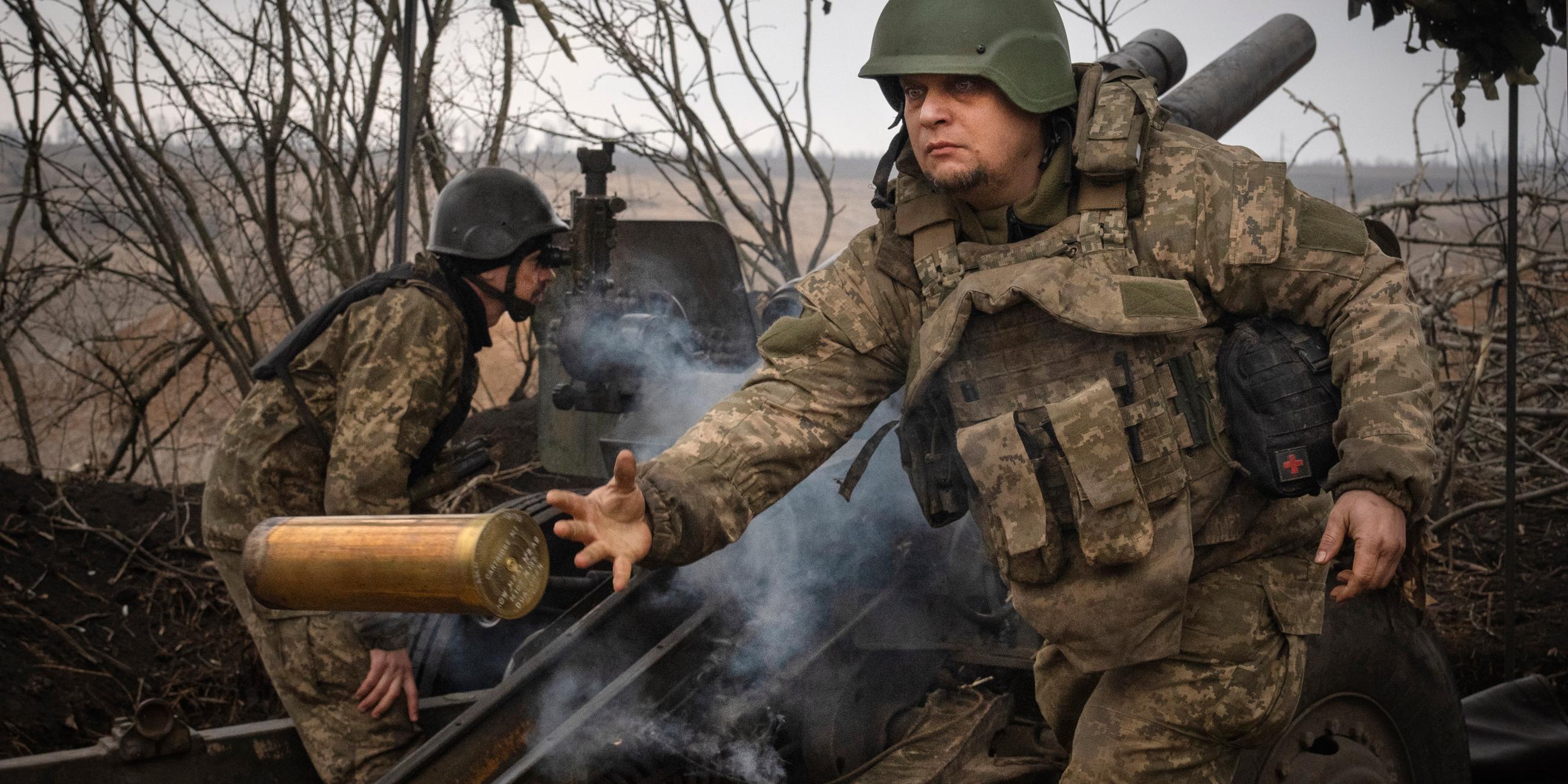 Ukraine, Awdijiwka: Ukrainische Soldaten der 71. Jägerbrigade feuern eine Haubitze M101 auf russische Stellungen an der Frontlinie. Archivbild