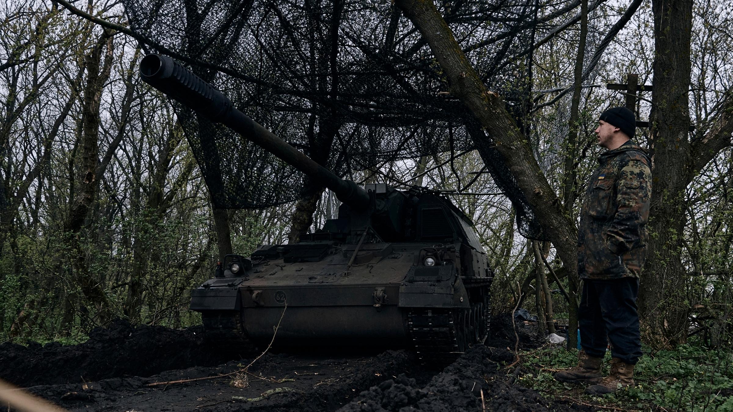 Ukraine, Bachmut: Ein ukrainischer Soldat steht neben einer deutschen Panzerhaubitze 2000, ein selbstfahrendes gepanzertes Artilleriegeschütz, in seiner Stellung an der Frontlinie.